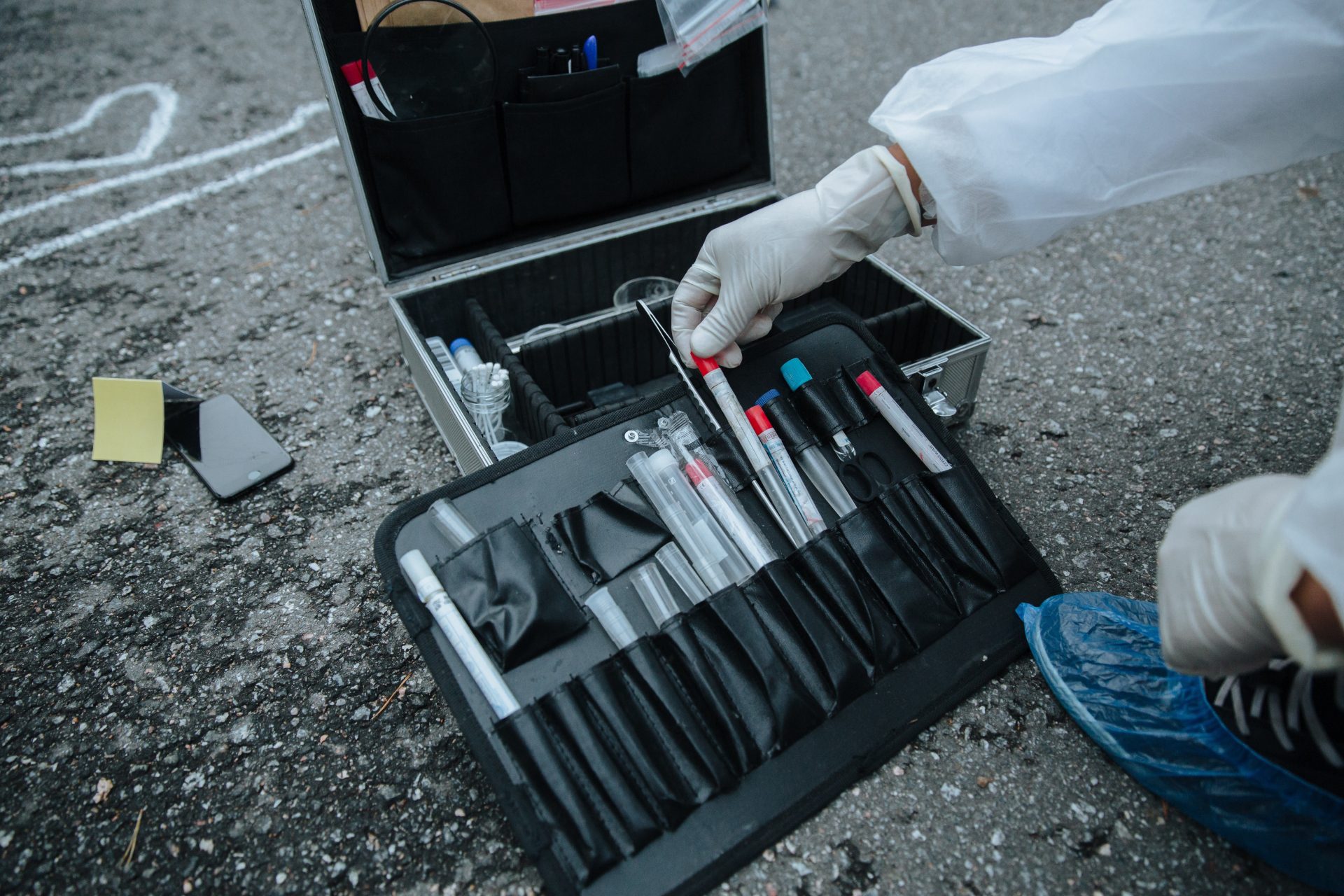 Nahaufnahme von Ermittlungsinstrumenten an einem Tatort, die Präzision und Detailgenauigkeit verdeutlicht.