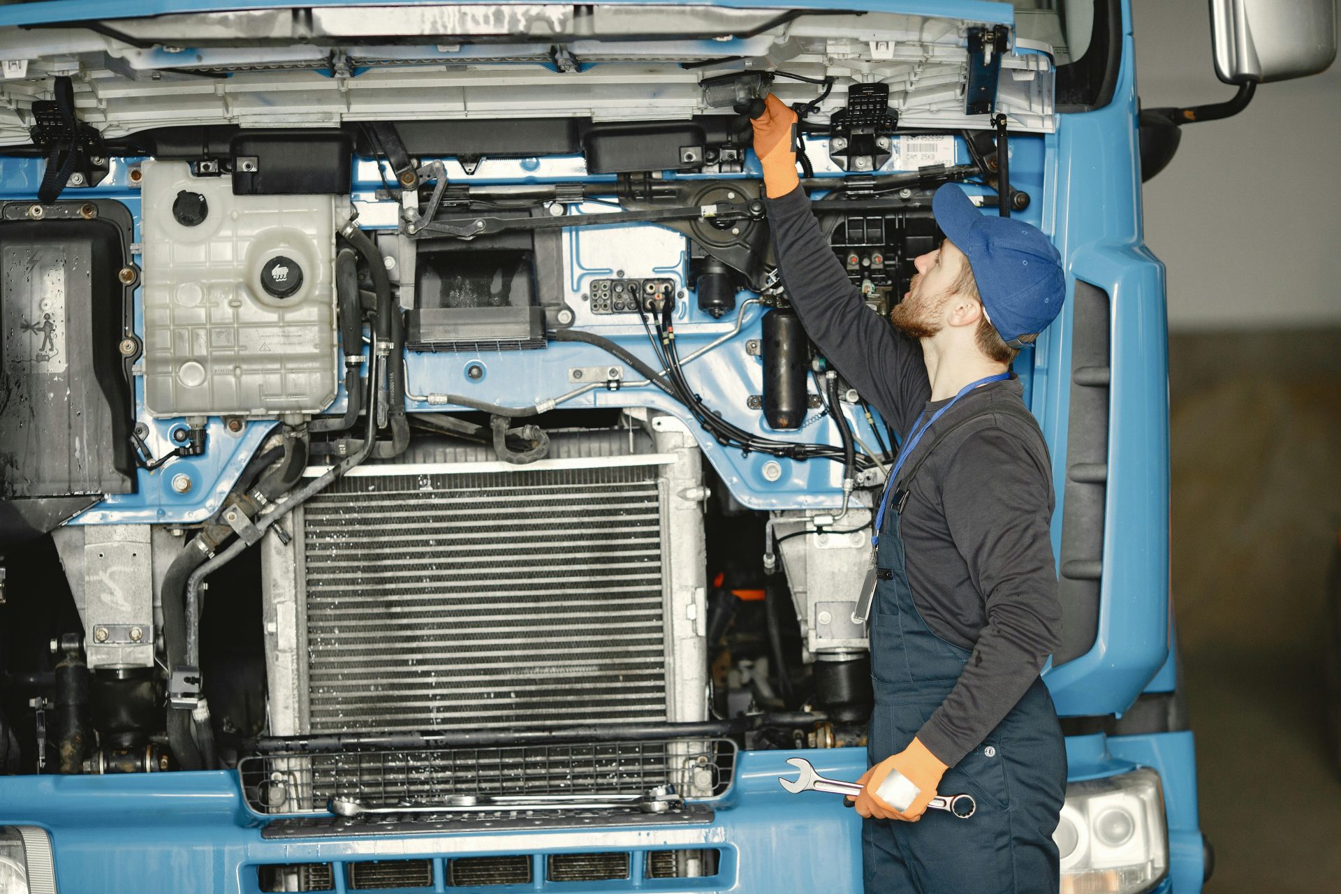 Ein Mechaniker arbeitet in einer Werkstatt an einem LKW-Motor und demonstriert dabei sein Fachwissen in der Fahrzeugreparatur.